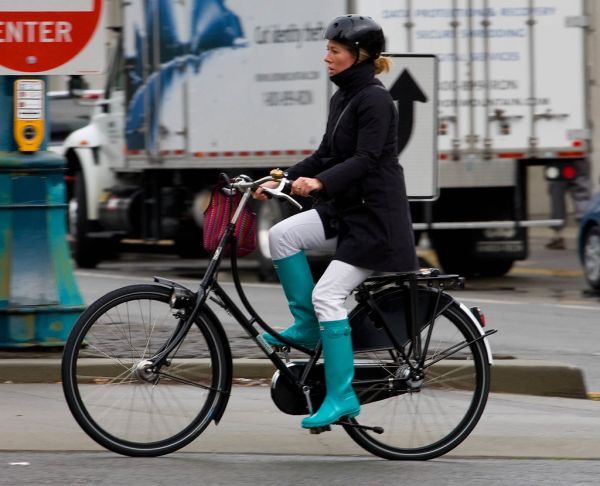Cycliste à vélo en ville, casque sur la tête, sur le chemin du travail