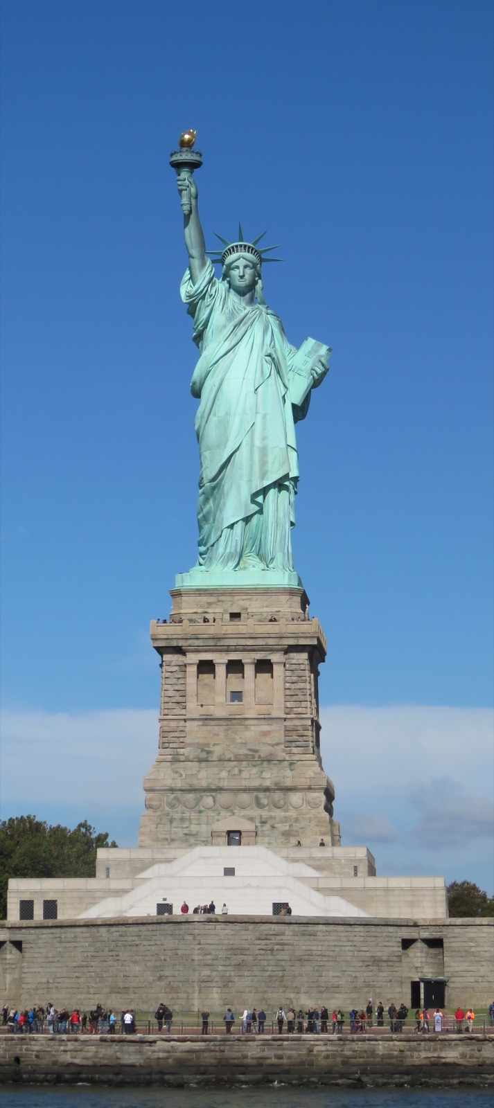 La Statue de la Liberté d'Auguste Bartholdi dans le port de New York, sous un ciel bleu