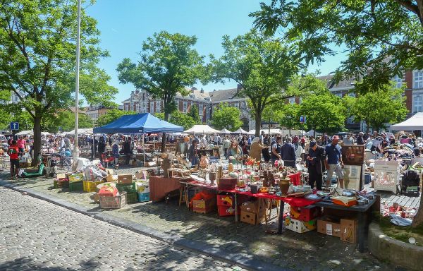 Étals de brocante en plein air avec objets vintage et vaisselle ancienne