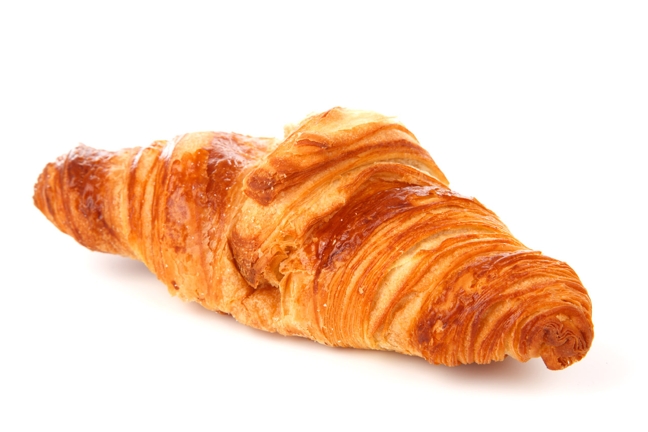 Un croissant au beurre doré et feuilleté posé sur fond blanc