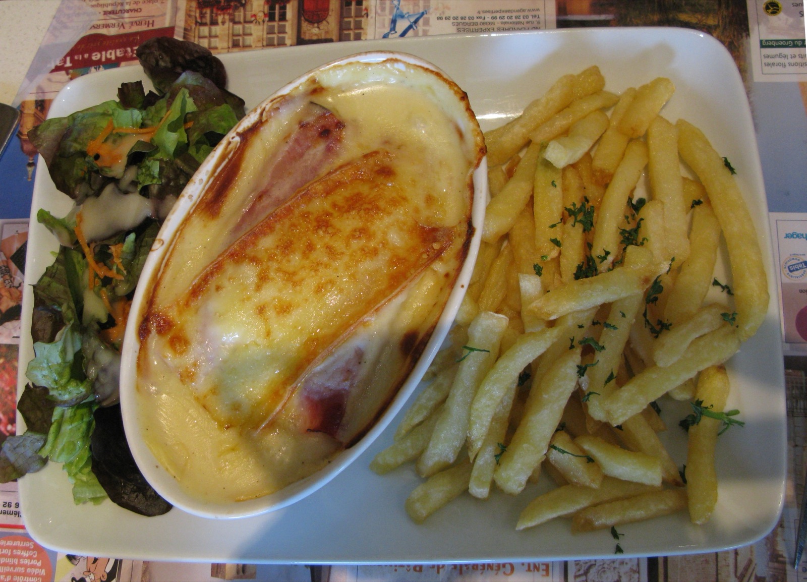 Chicon au jambon gratiné doré servi avec frites et salade, le plat emblématique à base d'endives