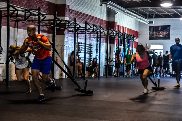 Groupe de pratiquants tirant des sleds lestés lors d'un WOD dans une box de CrossFit