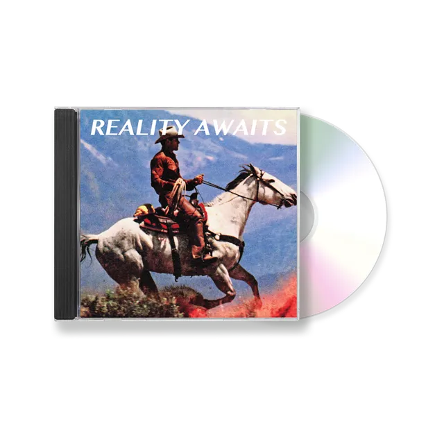 Pochette de l'album Reality Awaits des Strokes : un cavalier lance son cheval blanc au galop devant un paysage de montagnes
