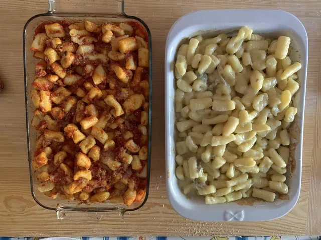 Deux plats de gnocchi de pomme de terre, l'un nappé de sauce tomate et ragù, l'autre au gorgonzola